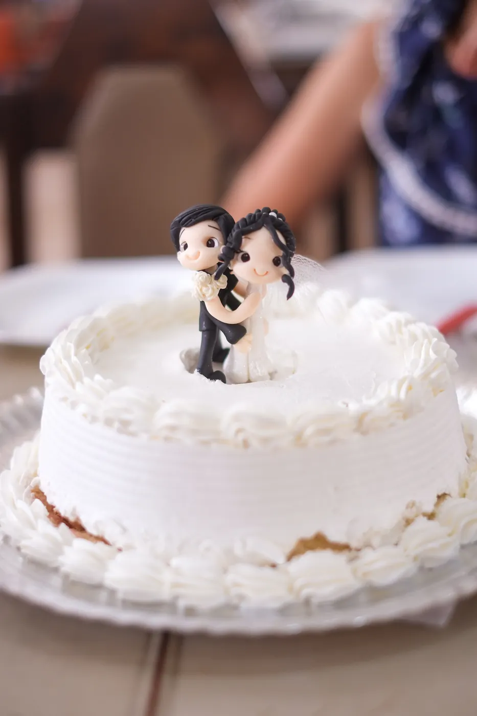 Bolo de casamento branco com os bonequinhos dos noivos no topo