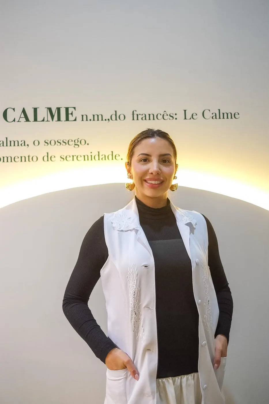 Profissional em frente à parede com a definição da palavra Le Calme